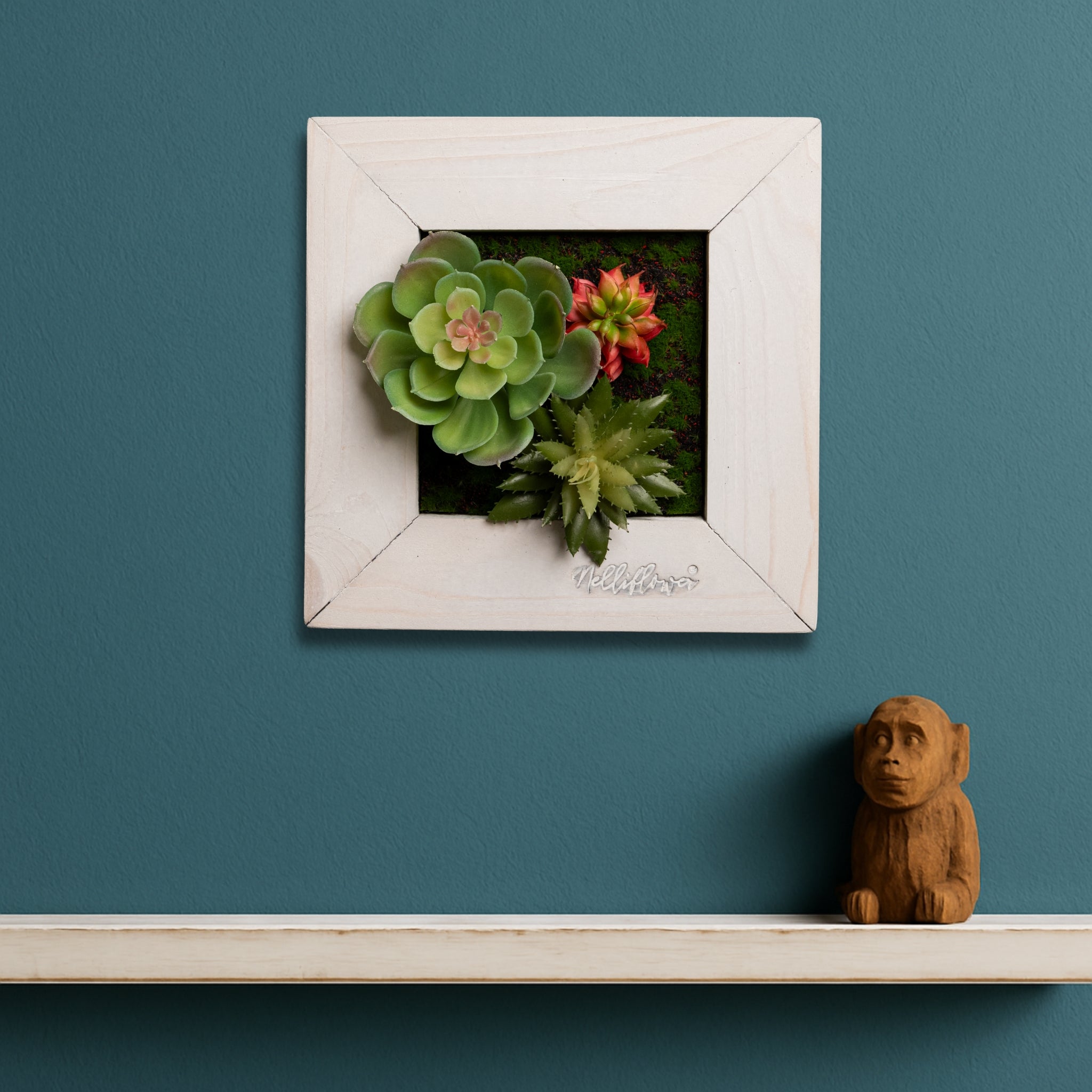 TinyFrame mit künstl. Sukkulenten im weißen Holzrahmen vor blauer Wand