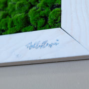 Nahaufnahme mit Logo künstl. Moosbild in weißen Holzrahmen