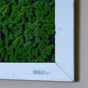 Nahaufnahme künstl. Moosbild mit Logo in weißen Holzrahmen